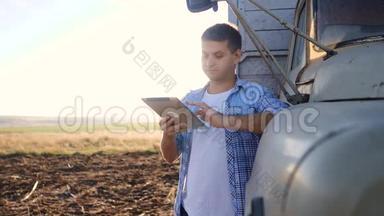 智慧农业。 男子农民司机站在卡车附近的数字平板电脑。 肖像商人农民站在